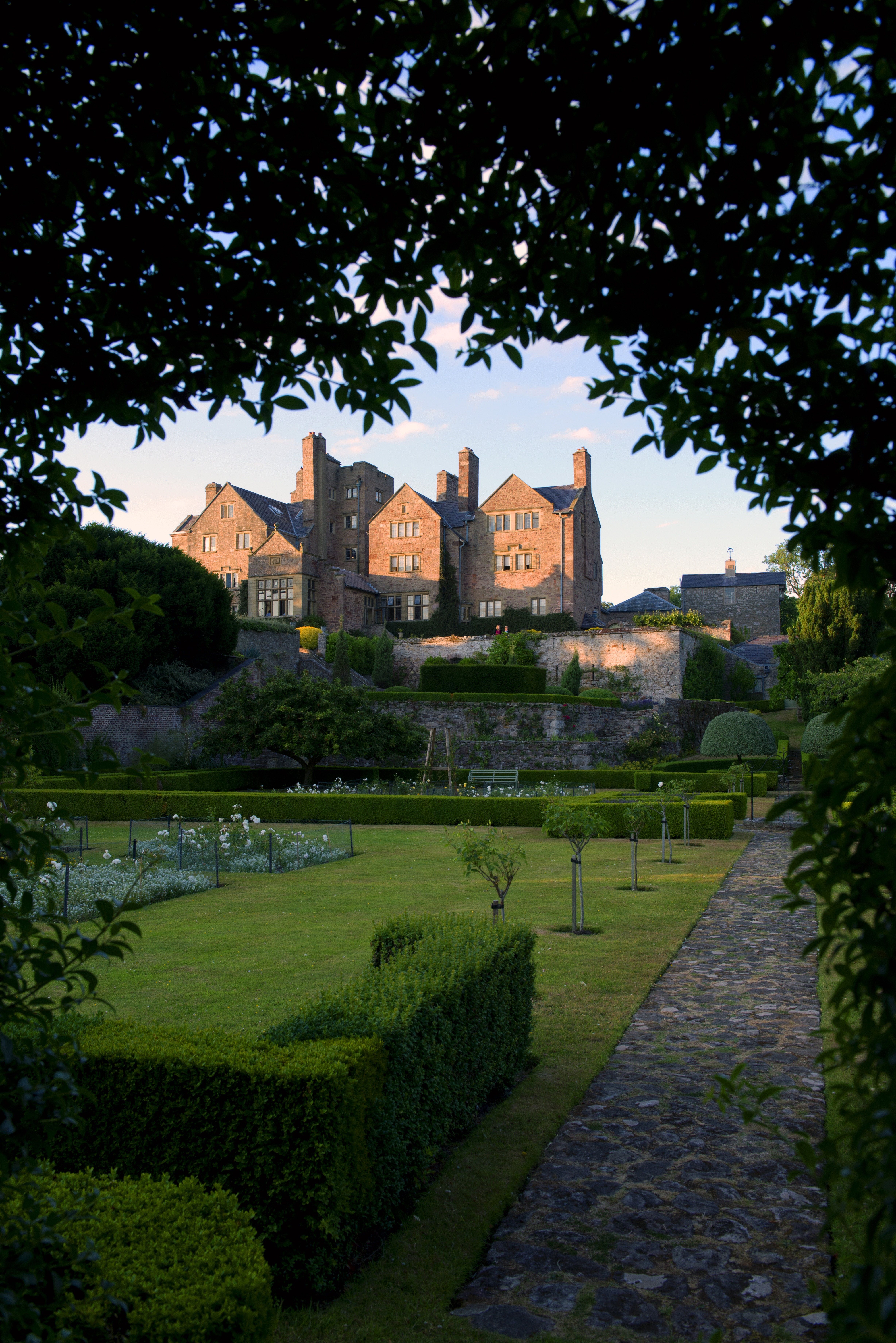 Bodysgallen Hall through arch and across rose garden