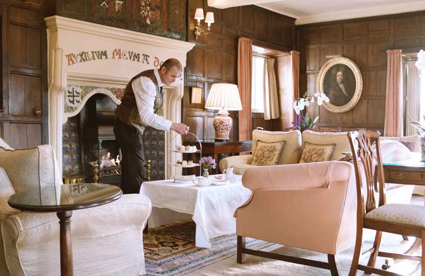 Waiter preparing Afternoon Tea in Drawing Room at Bodysgallen Hall Waiter preparing Afternoon Tea in Drawing Room at Bodysgallen Hall